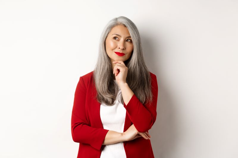 Woman in red jacket looking upwards thinking about image consultant training courses