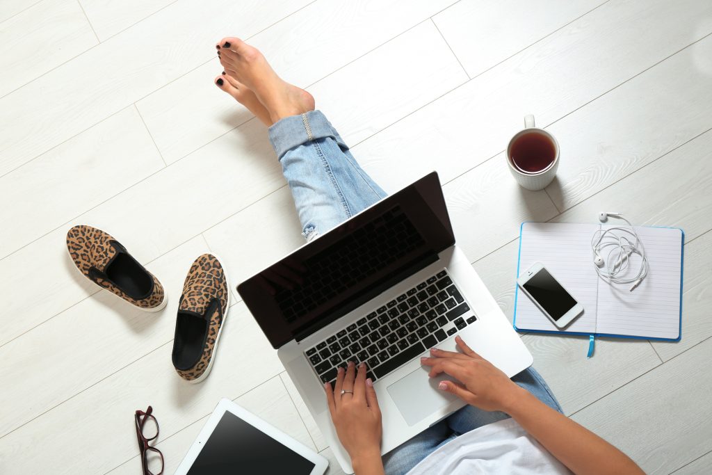 Woman sitting on the floor with laptop studying the colour and style consultant course